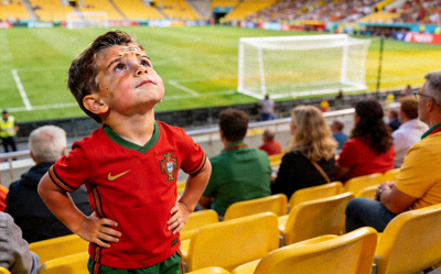 小球迷模仿球星表情 - 一个可爱的小男孩在看台上模仿C罗的经典庆祝表情，惟妙惟肖